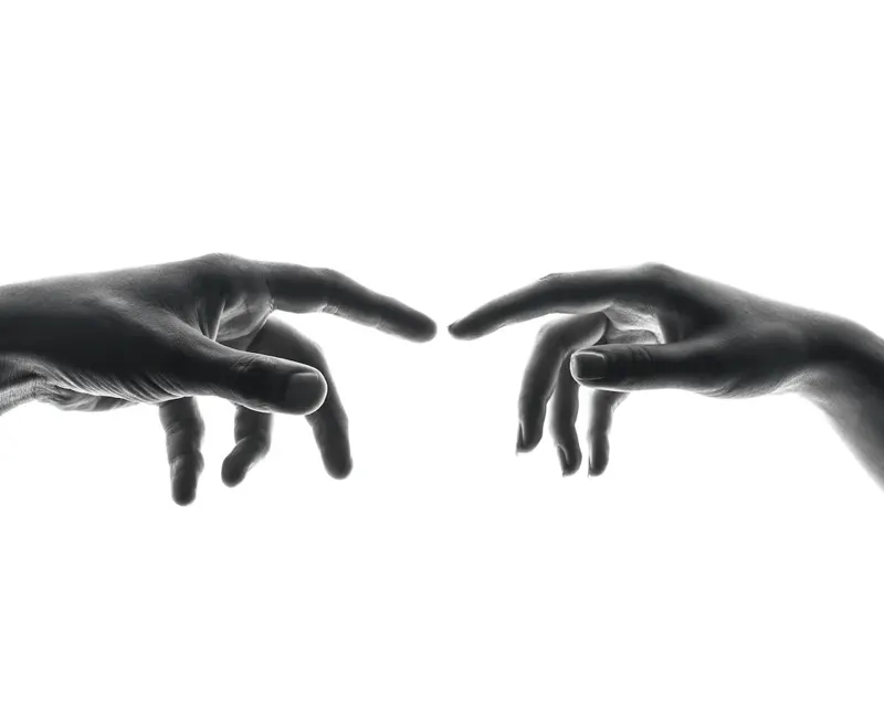 Two hands reaching toward each other