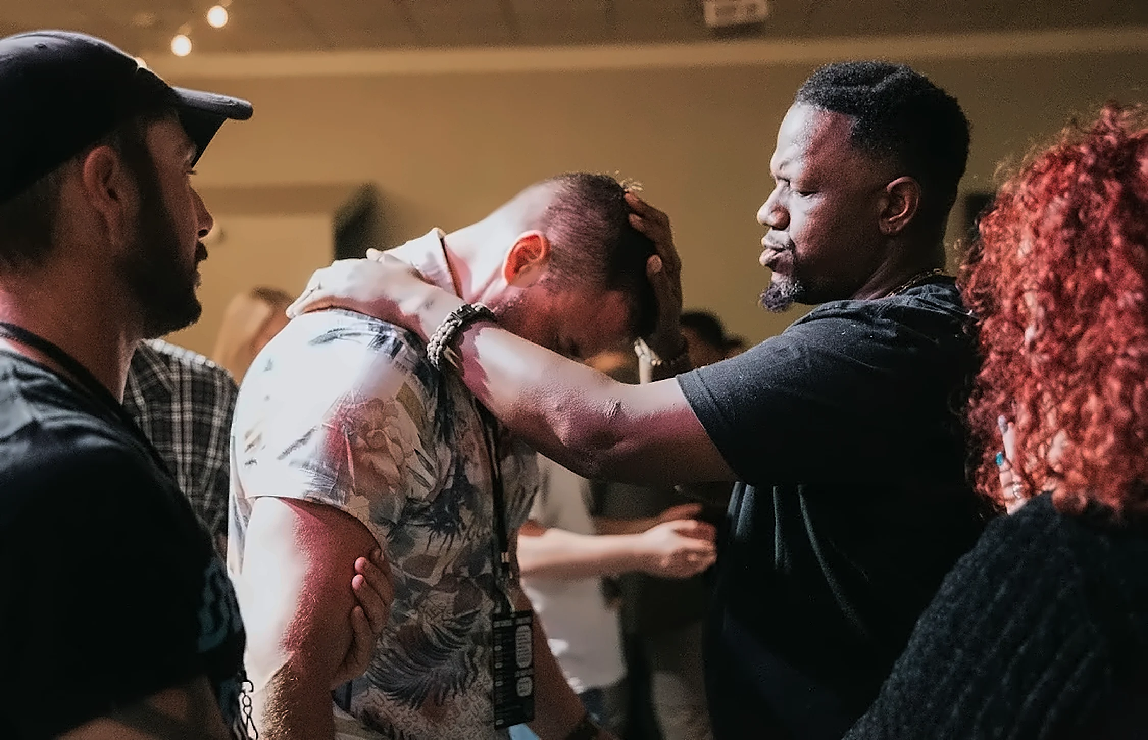 Erich Jeremiah Rose laying hands on a man in prayer during ministry